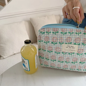 Detail of quilted floral makeup bag with tulip print and smooth metal zipper closure