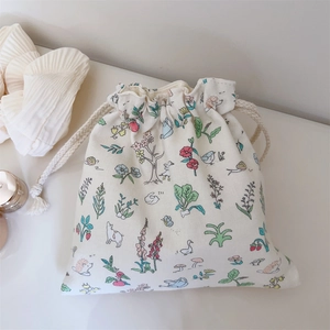 Détail d'un sac de rangement à cordon avec motifs floraux et animaux mignons en coton