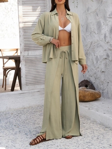 Close-up of light green linen set with side slit wide-leg pants and textured fabric details