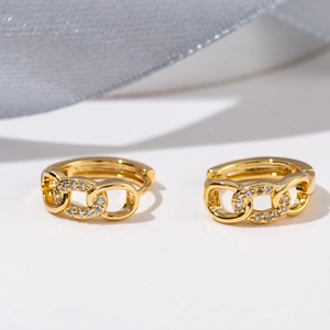 Close-up of gold chain huggie earrings featuring micro-pave white zircon stones