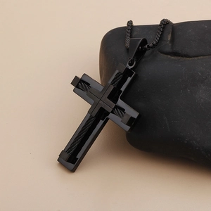 Minimalist black stainless steel cross pendant necklace on a natural stone background