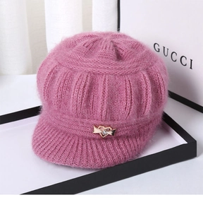 Detailed macro view of pink knit hat with golden heart rhinestone and soft fuzzy texture