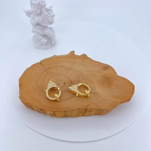 Pair of gold lobster clasps with micro-set zircons on a rustic wood display