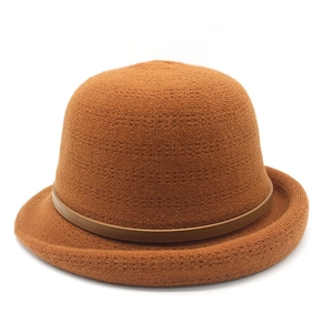 Detail of caramel knitted bucket hat showing close-up texture and leather buckle strap