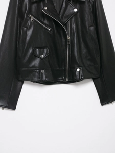 Detail view of black faux leather biker jacket with silver metal zippers and buttons