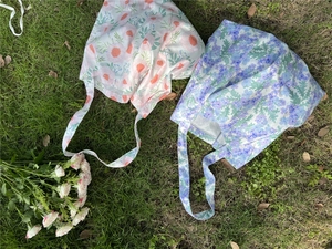 Flat lay detail of lightweight floral cotton tote bags with flower prints on grass
