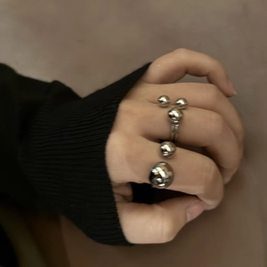 Polished stainless steel ring featuring spherical beads worn on hand with a minimalist style