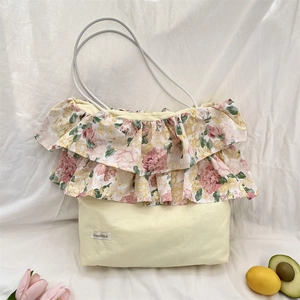 Dettaglio della balza floreale e dell'etichetta sulla borsa tote con rose vintage