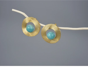 Detailed macro view of S925 silver round stud earring with turquoise bead and gold finish