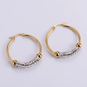 Macro view of gold hoop earrings featuring three rows of white cubic zirconia pavé
