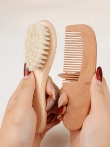 Close-up of a wooden wool baby hairbrush and a semi-circle wooden comb set