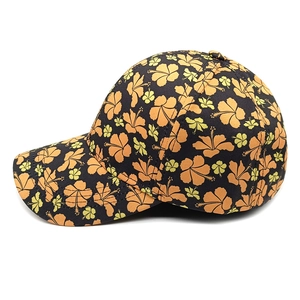 Detailed close-up of a floral baseball cap with orange hibiscus patterns and stitching