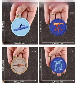Detail view showing scale of 5cm round embroidered patches with scouting patterns