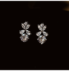 Macro shot of silver floral earrings with round and marquise-cut zircon stones