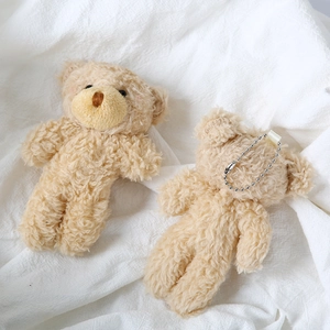 Detailed view of plush teddy bear charms with curly fur and silver ball chain attachments