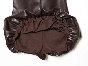 Dettaglio della minigonna in ecopelle marrone scuro con pantaloncini di sicurezza