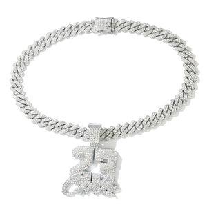 Detailed view of silver cuban chain and iced-out 23 Savage pendant with shimmering stones