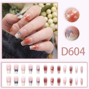 Faux ongles dégradés roses avec nœuds 3D bleus et motifs étoiles et cœurs blancs