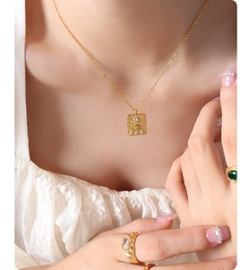 Detail view of a 18K gold-plated Egyptian relief square pendant with zircon inlay