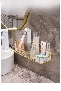 Detail of golden iron bathroom shelf showing its open wire design on marble wall