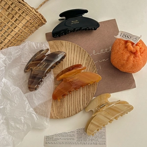 Set of four large acetate hair claws in black and amber brown displayed in ins style