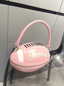 Close-up of pink football shaped handbag with leather texture and metal buckle details