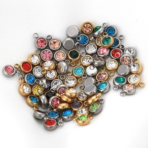 Close-up of colorful round rhinestone charms in gold and silver settings for DIY jewelry