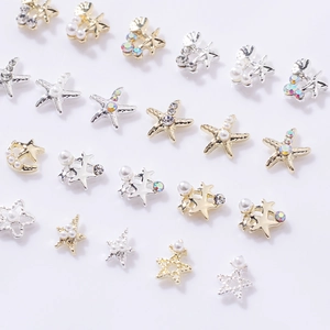 Macro shot of assorted gold and silver hollow star and starfish nail art charms with pearls