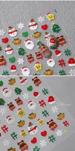 Macro detail of 3D embossed Christmas nail art stickers with Santa and snowman patterns
