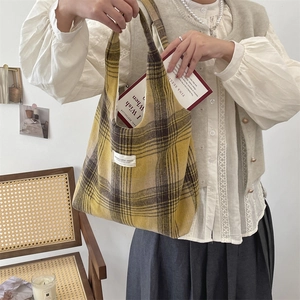 Dettaglio della borsa tote vintage in lana a quadri con etichetta Mara Canvas Studio