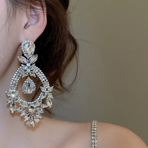 Close-up of elegant silver needle drop earrings with sparkling marquise and pear rhinestones