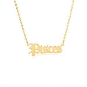 Detailed close-up of golden Pisces gothic letter pendant on a fine link chain necklace