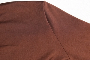 Detailed close-up of brown long sleeve dress showing fine twill fabric and stitching