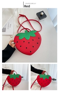 Detail view of strawberry-shaped red crossbody bag with green sequin leaf design