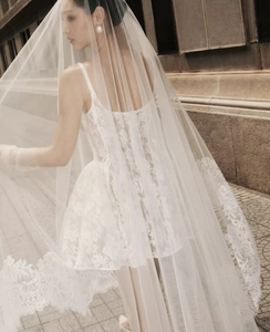 Gros plan sur une robe courte en dentelle blanche élégante avec voile transparent assorti