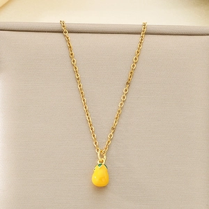 Dettaglio della collana con ciondolo a pera gialla con foglia verde e catena d'oro
