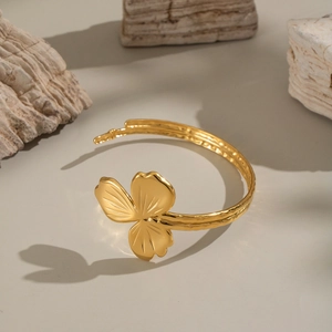 Bracelet jonc trèfle doré élégant avec une texture martelée sur un support en pierre