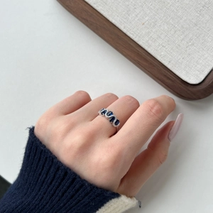 Detail showing S925 silver ring with blue oval heart gems and white zircons on hand