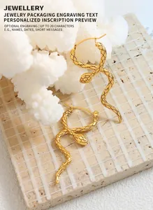Detailed close-up of golden snake earrings with textured scales on white coral stand