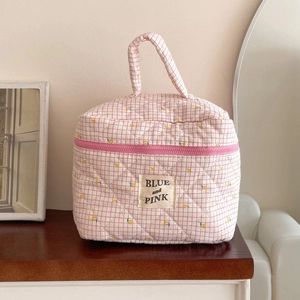 Detailed view of pink checkered quilted cotton makeup bag with floral embroidery