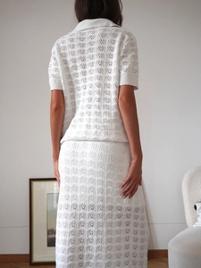 Back view of a white knitted set featuring hollow-out lace patterns and a long maxi skirt