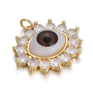 Macro shot of evil eye pendant featuring white zirconia stones and gold plating