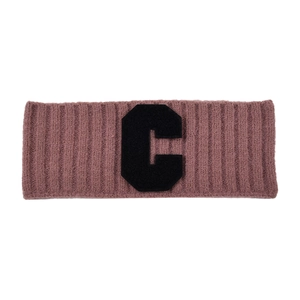 Détail du bandeau tricoté rose avec un écusson noir lettre C et texture côtelée