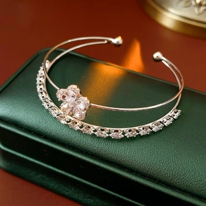 Vue macro d'un bracelet ouvert à deux couches avec fleurs en zircon sur cuir vert
