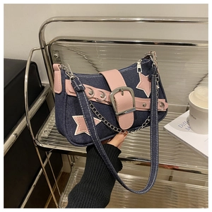 Detail of blue denim star bag with pink leather trim and metallic chain strap