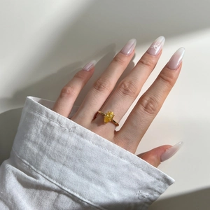 Close-up of luxury pear-cut yellow zircon ring on hand model with a golden S925 silver band