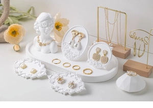 French retro gold earrings and pearl necklaces on white plaster jewelry display stands