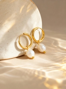 Close-up of 18K gold-plated hoop earrings with elegant white freshwater pearls detail