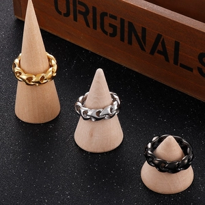 Detailed view of gold, silver, and black cuban chain rings on wooden display stands
