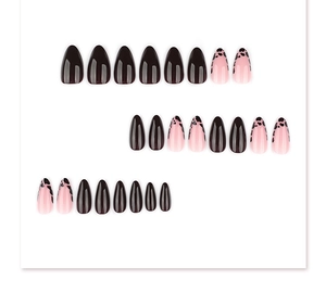 Flat lay of almond-shaped press-on nails featuring black gloss and cow print patterns